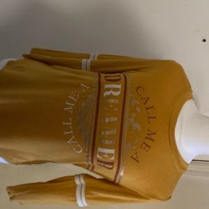 Mustard yellow shirt that says “I am a dreamer”